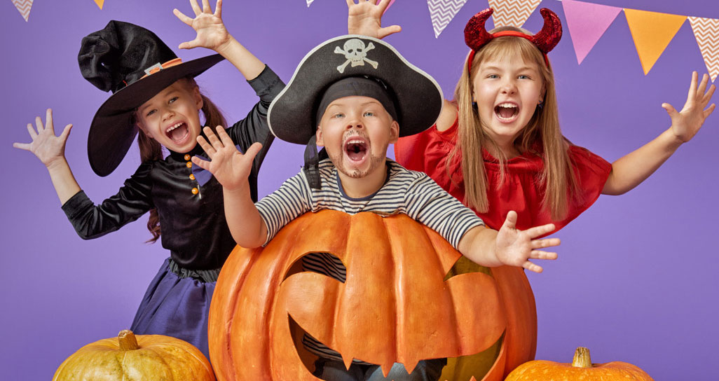 Brother and two sisters dressed in Halloween costumes