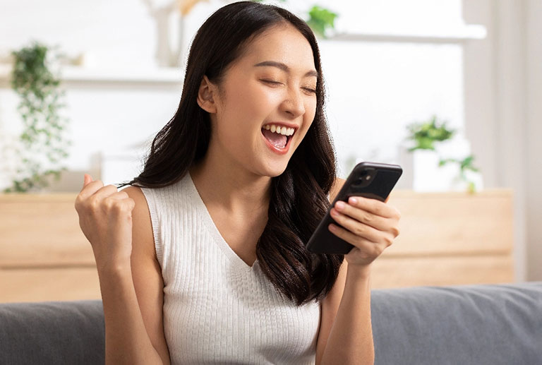 Woman with successuful expression holding phone